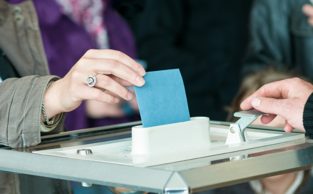 photo d'une main deposant un bulletin de vote