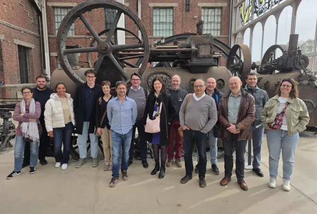 Les représentants du consortium posent devant d'anciennes machines minières au centre historique minier de Lewarde
