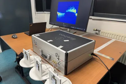 Photo du dispositif de détection de mouvement par radar : sur une table sont posés des capteurs et une valise de matériel reliés à un ordinateur