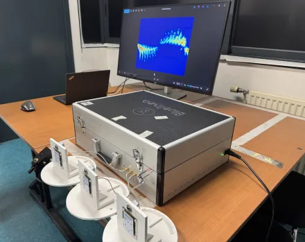 Photo du dispositif de détection de mouvement par radar : sur une table sont posés des capteurs et une valise de matériel reliés à un ordinateur